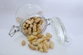 Glass jar with lots of peanuts on a white background Royalty Free Stock Photo